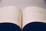 A close-up of an open book with blurred pages in an indoor setting, conveying focus and reading.